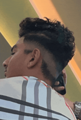a man with curly hair is wearing a watch