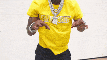 a man wearing a yellow balmain t-shirt
