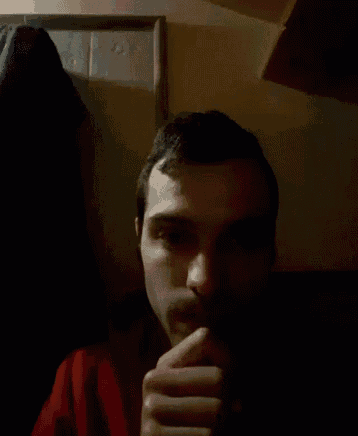 a man in a red sweater looks at the camera