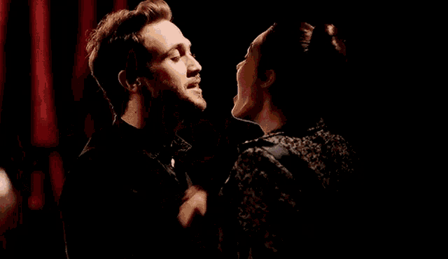 a man and a woman are dancing in a dark room