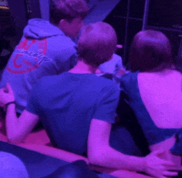 a man wearing a hoodie that says worship is sitting with two other people