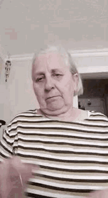 a woman in a striped shirt is making a funny face .