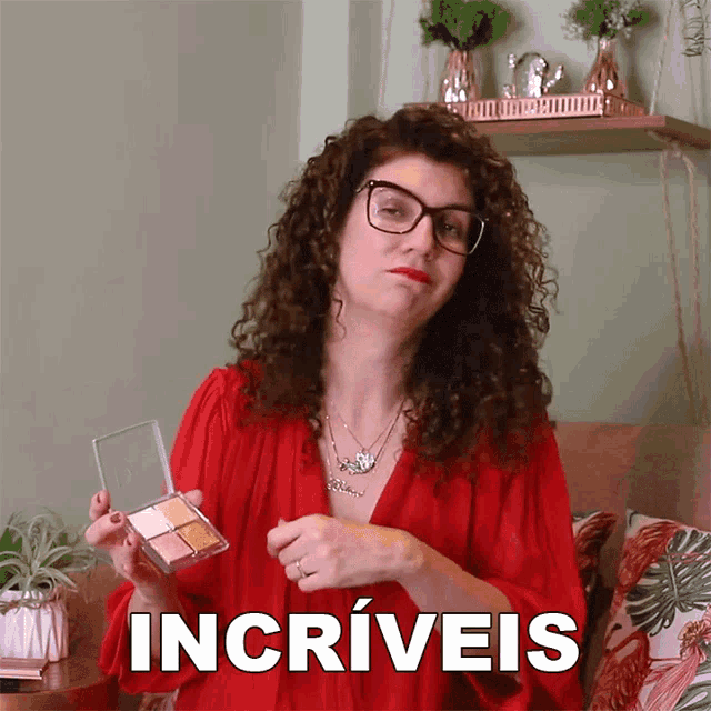 a woman with curly hair and glasses is holding a palette of makeup and the word incrivels is written above her