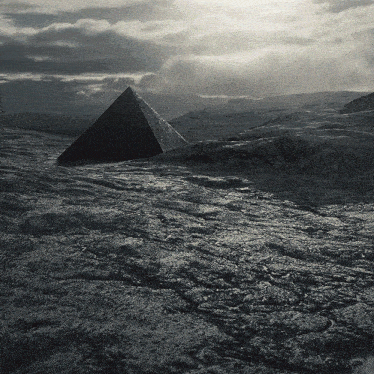 a black and white photo of a pyramid in the middle of a rocky field