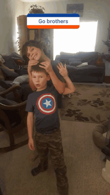 two young boys in a living room with a go brothers sticker