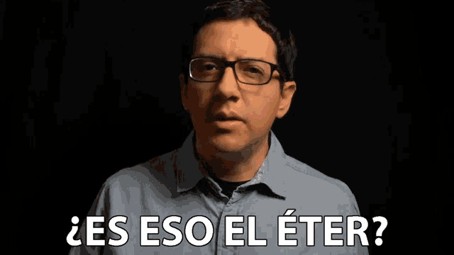 a man wearing glasses says " es eso el eter " in a dark room