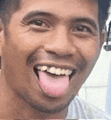 a close up of a man with his tongue out .