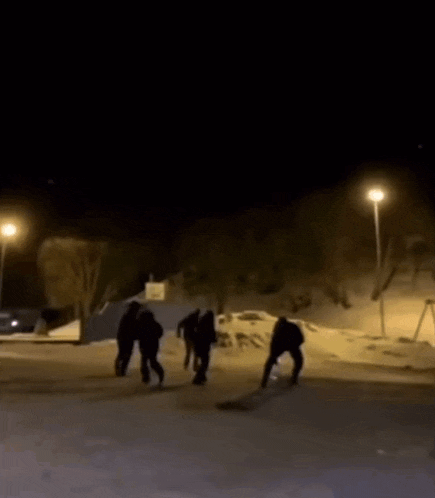 a car is driving down a snowy street at night