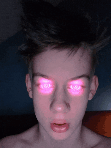 a close up of a boy 's face with pink eyes