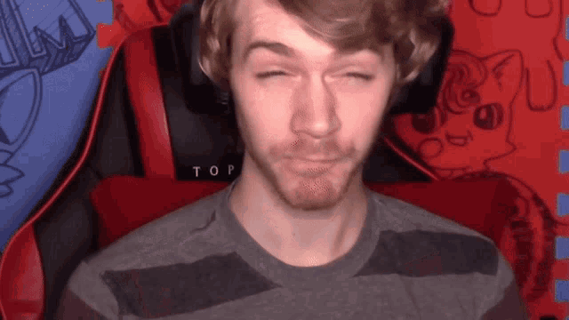 a man is sitting in a chair with the word top on the back