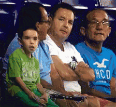 a boy wearing a hollister shirt sits in the stands