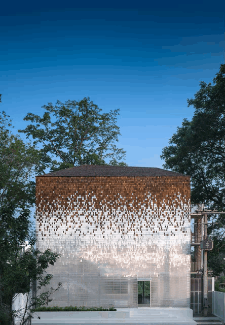 a building with a blue sky behind it and trees in front of it