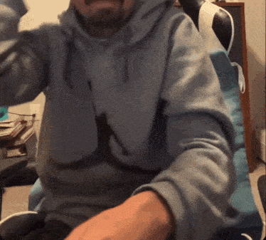 a man wearing a grey hoodie with a silhouette of a man on it