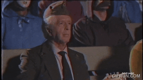 a man in a suit and tie is playing a mandolin in front of people