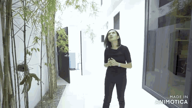 a woman standing in a hallway with the words made in animatica on the bottom right