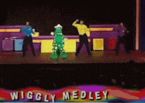 wiggly medley performs on a stage with a green monster