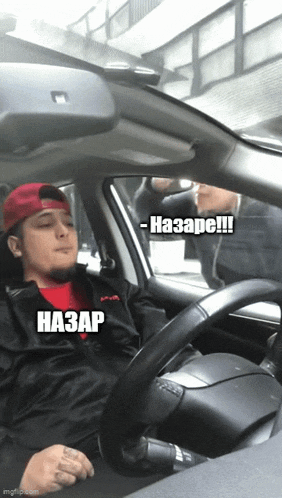 a man in a red hat is driving a car with a caption that says - nazare !!