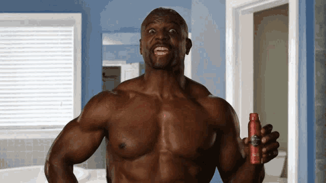 a shirtless man is holding a bottle of deodorant in his hand