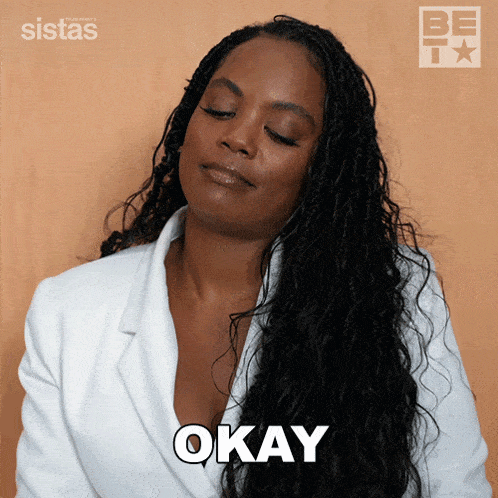a woman wearing a white jacket says okay