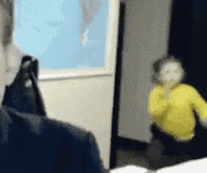 a blurry picture of a man and a child in a room