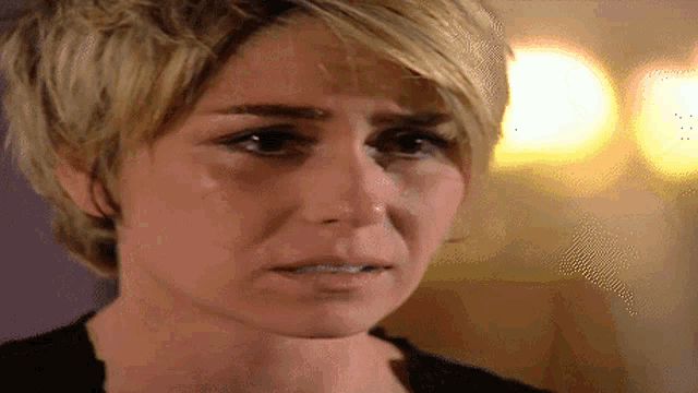 a close up of a woman 's face with a tear coming out of her nose