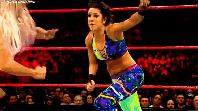 two women are wrestling in a ring and one of them is wearing a neon outfit