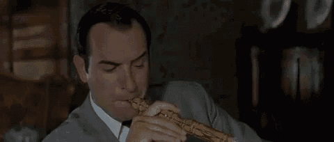 a man in a suit and tie is holding a crab and saying c ' est bon ca ... j 'aime bien ...