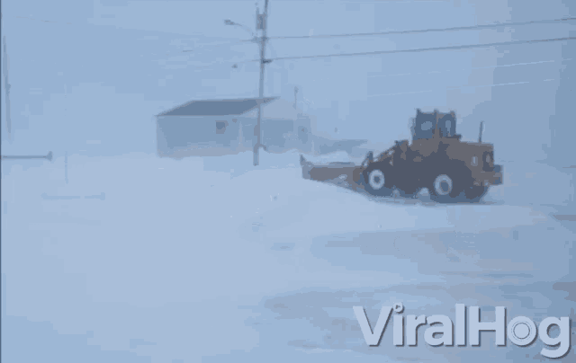 a snow plow is driving through a snowy area with viralhog written in the bottom right corner