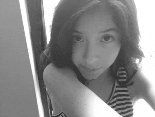a black and white photo of a girl wearing a striped top