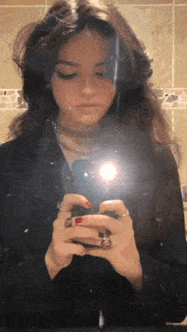 a woman taking a picture of herself in a bathroom mirror