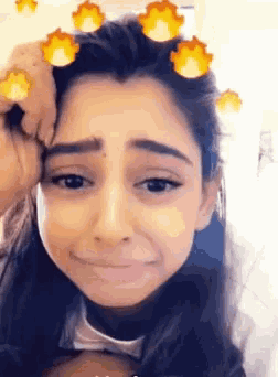 a girl is making a funny face with a fire filter on her face