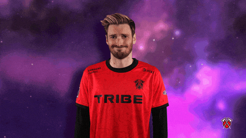 a man wearing a red tribe shirt stands in front of a purple background