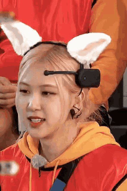 a close up of a person wearing a headband with cat ears and a microphone .