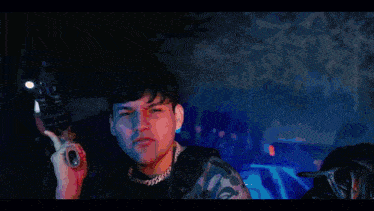 a young man with a chain around his neck is giving the ok sign