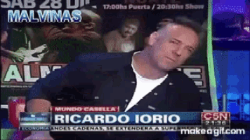 a man is sitting in front of a screen that says ricardo iorio on it