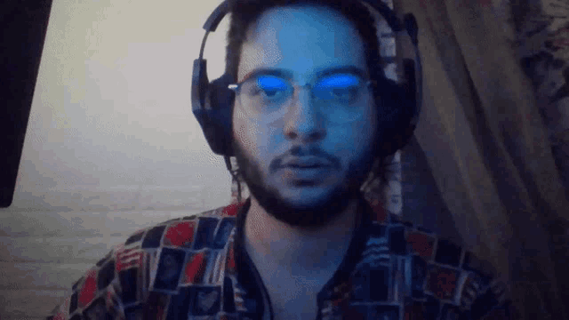 a man wearing glasses and headphones is looking at the camera