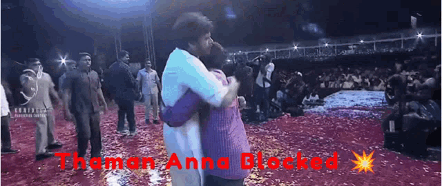 a man is hugging another man in front of a crowd with the words " theman anna blocked " written on the bottom