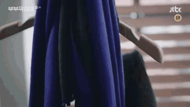 a blue scarf is hanging on a hanger in a room .