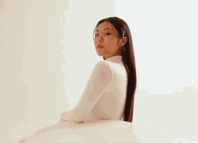 a woman in a white shirt has a red flower in her hand
