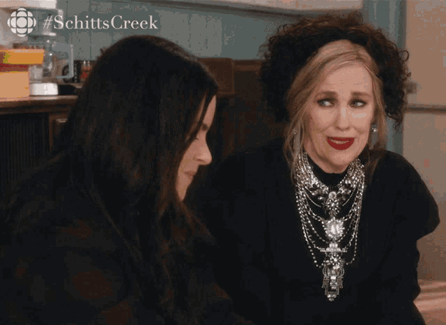 two women are sitting next to each other with the words we 're in this together