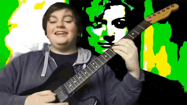 a man playing a guitar in front of a green and yellow painting