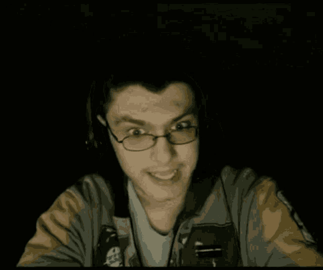 a man wearing glasses and a jacket with a sticker on it that says ' a '