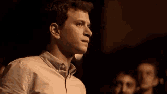 a man in a white shirt stands in front of a crowd of people