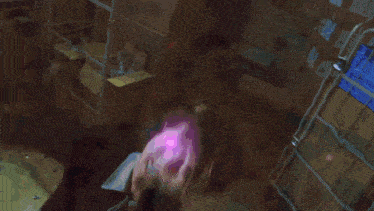 a large explosion in a dark room with a purple light coming out of it