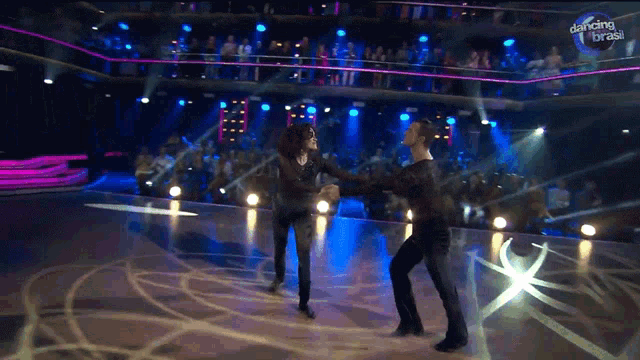 a couple of people dancing on a stage with dancing brasil written on the bottom