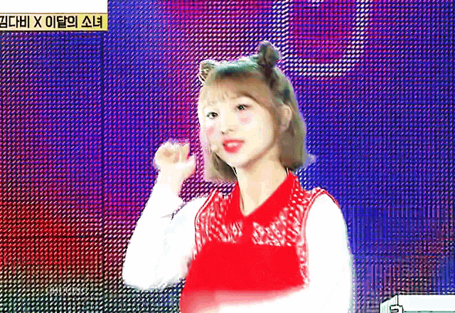 a girl in a red top is standing in front of a screen with chinese writing on it .