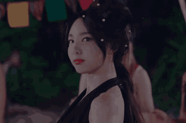 a woman in a black dress with pearls in her hair