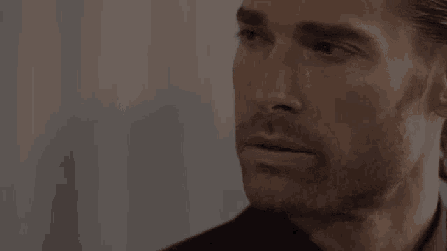 a close up of a man 's face with a tear coming down his eye .