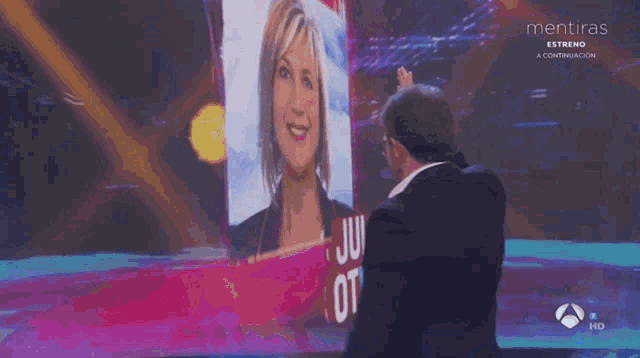 a man stands in front of a screen with julia otero on it