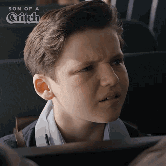 a young boy is making a funny face with the words son of a grifch behind him